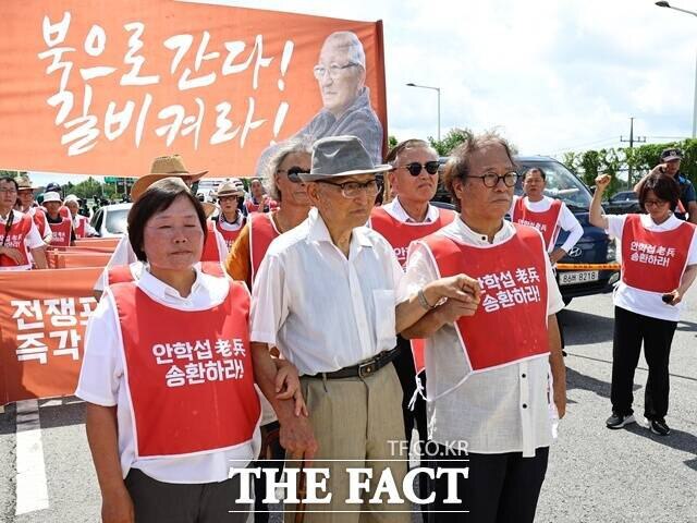 비전향 장기수 안학섭(95) 씨는 20일 북한으로의 송환을 요구하며 파주시 통일대교 진입을 시도했으나 군 당국에 의해 제지됐다. 사진은 안 씨(가운데)가 이날 통일대교 남단에서 안학섭송환추진단과 함께 검문소를 향해 이동하고 있다. /뉴시스