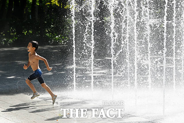 어린이가 바닥분수에서 즐거운 시간을 보내고 있다.