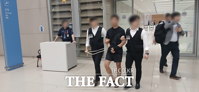 그룹 방탄소년단(BTS) 정국과 국내 재력가들의 자산을 탈취한 혐의를 받는 중국 해킹조직 총책이 구속됐다. 법무부 관계자들이 22일 오전 해킹조직 총책인 중국 국적 A(34) 씨를 인천국제공항을 통해 강제송환하고 있다./법무부