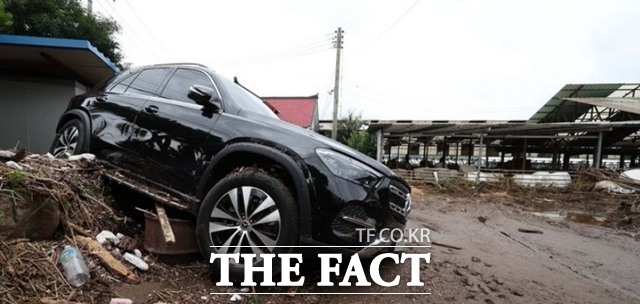 21일 경기 가평군 대보교 인근 주택 마당에서 차량이 폭우 피해를 입고 기울어 있다. /뉴시스