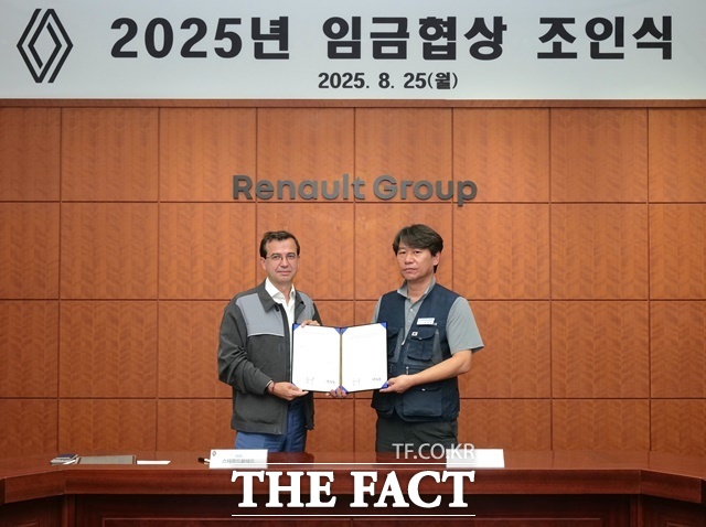 르노코리아 스테판 드블레즈 사장(왼쪽)과 박종규 노동조합 위원장이 25일 부산공장에서 열린 2025년 임금협상 조인식에서 합의안에 서명 후 기념 촬영을 하고 있다. /르노코리아