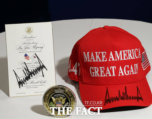 대통령실이 25일(현지 시간) 공개한 도널드 트럼프 미국 대통령이 정상회담 후 이재명 대통령에게 준 선물. 백악관 기념 메달과 트럼프 대통령이 사인을 한 마가(MAGA·Make America Great Again·미국을 다시 위대하게) 모자와 오찬 메뉴판. /워싱턴=뉴시스
