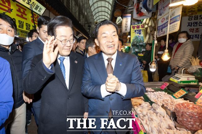 지난해 12월 이재준 수원시장이 이재명 당시 더불어민주당 대표와 못골·영동시장을 둘러보며 환한 미소로 상인들에게 인사하고 있는 모습. /수원시