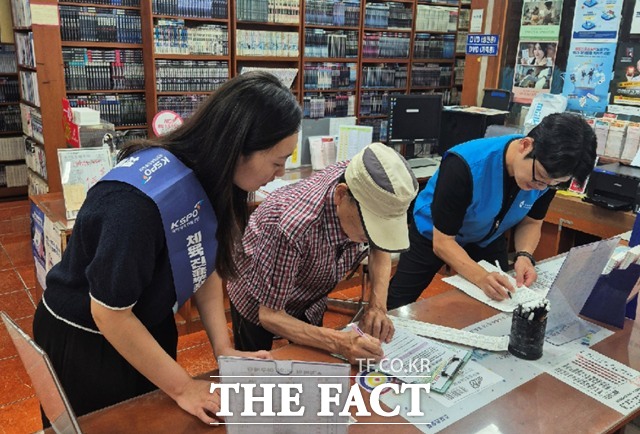 한국스포츠레저 및 한국도박문제예방치유원 관계자들이 판매점 내에서 한 시민에게 캠페인 활동을 전개하고 있다./한국스포츠레저