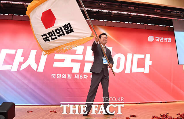 장동혁 국민의힘 신임 당대표가 26일 오전 서울 여의도 국회 도서관에서 열린 제6차 전당대회 결선에 참석해 당기를 흔들고 있다. /국회=배정한 기자