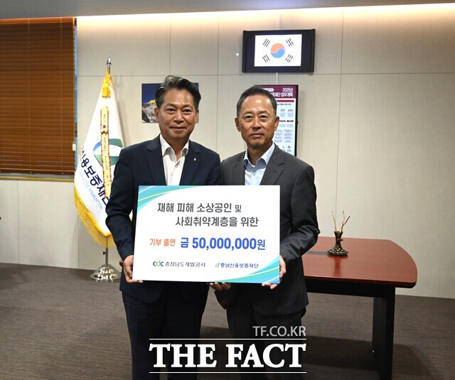 김병근 충남개발공사 사장(우측)이 조소행 충남신보 이사장에게 집중호우 피해 소상공인을 위한 출연금 5000만 원을 기탁하고 있다. /충남개발공사