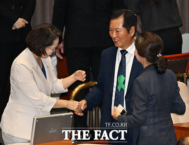 오송 참사 추모 의미의 초록 리본을 목에 건 정청래 더불어민주당 대표가 27일 오후 서울 여의도 국회에서 열린 본회의에 참석해 조국혁신당 의원들과 대화를 하고 있다. /국회=배정한 기자