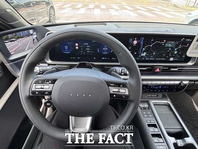 운전석에서 바라본 조향 휠과 디지털 클러스터·인포테인먼트 화면. 좌측은 속도계 및 주행 정보, 스티어링 휠 좌우에는 주행 보조, 미디어, 크루즈 컨트롤 버튼이 배치돼 있고, 사이드미러 카메라 화면도 계기판 옆에 띄워져 있다. /황지향 기자