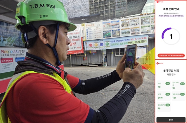 현장 근로자가 롯데건설이 건설사 최초로 개발한 건강체크 어플을 사용 중이다. /롯데건설