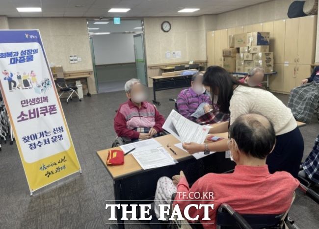 광명시 공무원이 요양시설에서 민생회복 소비쿠폰 신청을 지원하고 있다./광명시