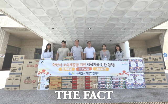 제101회 행복키움 행사에 앞서 후원 물품 배부를 준비 중인 아산시기업인협의회 관계자들이 기념 촬영을 하고 있다./아산시