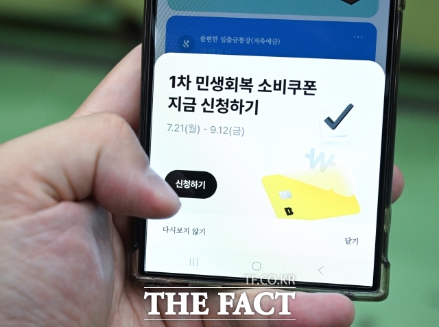 민생회복 소비쿠폰 신청 첫날인 지난 7월 21일 오전 경기 과천시에서 한 직장인이 민생회복 소비쿠폰을 신청하고 있다. /박헌우 기자