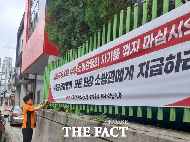 한 소방관이 대구의 한 119안전센터 앞에서 대구시의 구조구급활동비 차별 지급에 항의하는 현수막을 붙이고 있다. /전국공무원노동조합 대구소방지부