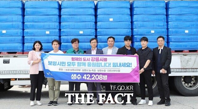 보령시가 극심한 가뭄으로 어려움을 겪는 자매도시 강릉시에 생수 4만 2208병을 긴급 전달하며 강릉시 관계자들과 기념촬영을 하고 있다. /보령시