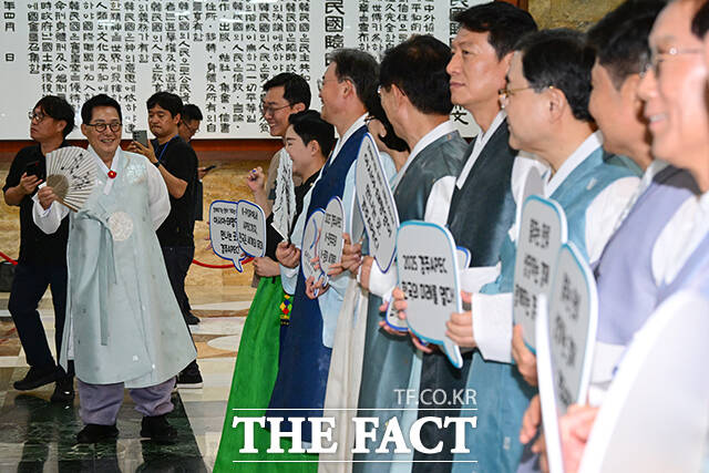 더불어민주당 박지원 의원이 한복을 입은 채 본회의장 앞에서 APEC 성공 개최를 기원하는 의원들을 보며 미소짓고 있다.