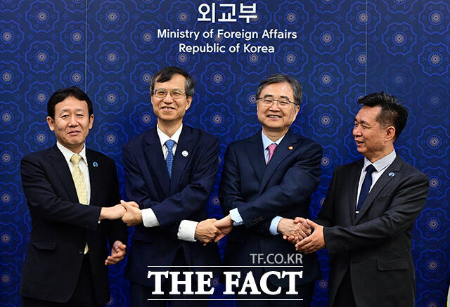 조현 외교부 장관(왼쪽 세 번째)이 3일 오전 서울 종로구 외교부에서 열린 한일중 3국협력사무국(TCS) 사무총장단 접견에 참석해 이희섭 사무총장, 즈시 슈우지 사무차장, 옌 량 사무차장과 손을 맞잡고 있다. /임영무 기자