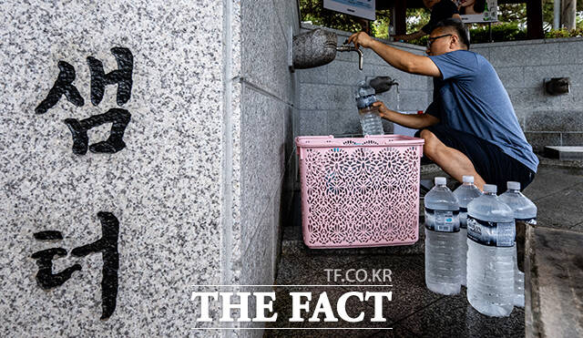 생활용수를 확보하기 위해 대관령 샘터를 찾은 시민들이 식수로 사용할 물을 받고 있다.
