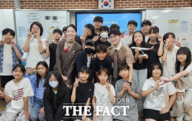 3일 서울공진초등학교에서 열린 항공진로 직업특강에서 (가운데 왼쪽부터) 이민정 부사무장, 이동준 부기장이 학생들과 기념 촬영을 하고 있다. /아시아나항공