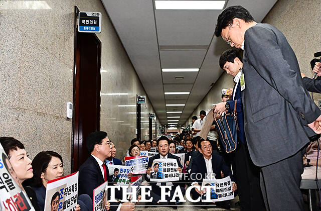 국민의힘 의원들이 3일 오후 서울 여의도 국회 국민의힘 원내대표실 앞 복도에서 내란 특검의 압수수색 시도를 저지하기 위해 농성을 벌이고 있는 가운데 내란 특검 수사관들(오른쪽)이 압수수색을 위해 대기하고 있다. /국회=배정한 기자