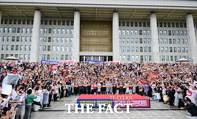 국회 앞에 모인 국민의힘 소속 국회의원과 당원들이 모여 규탄 구호를 외치는 모습.