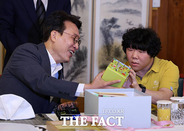 김민석 국무총리(왼쪽)가 4일 오후 서울 종로구 총리공관에서 열린 발달장애인 가족 초청 행사에 참석해 장애인 가족이 준비한 선물을 관심있게 바라보고 있다. /임영무 기자