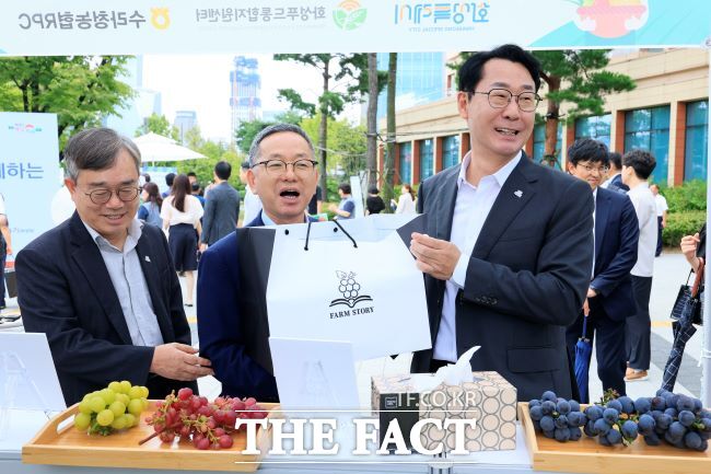 정명근 화성시장(오른쪽 첫번째)이 4일 국회 로컬푸드 직거래 장터에서 송산포도를 살펴보며 농업 관계자들과 대화하고 있다./화성시