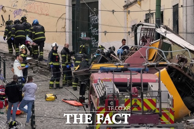 3일(현지 시간) 포르투갈 리스본에서 발생한 전동 케이블 전차 푸니쿨라 탈선 현장에서 소방관들이 희생자 시신을 옮기고 있다. /뉴시스