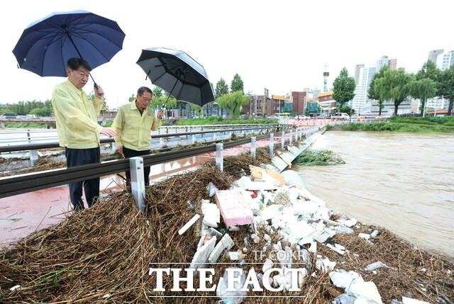 7일 오전 전북 전주시 완산구 태평동 전주천변 어은쌍다리에서 우범기 전주시장(왼쪽)이 관계 공무원과 함께 떠내려온 부유물과 각종 쓰레기 등으로 뒤엉켜 있는 하천을 보며 현장점검을 하고 있다. /전주시