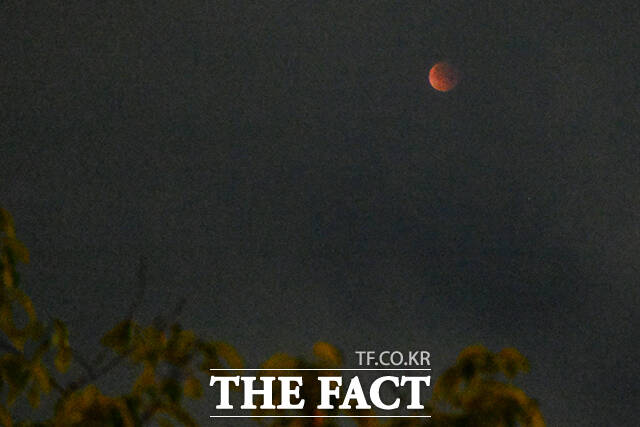 구름 사이로 살짝 드러난 개기월식의 순간.