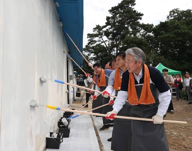 강호동 농협중앙회 회장(오른쪽)이 8일 경기 평택시 포승읍 신영리마을에서 사랑의 집고치기 봉사활동에 참여하며 주택 담장 페인트칠을 하고 있다. /농협중앙회