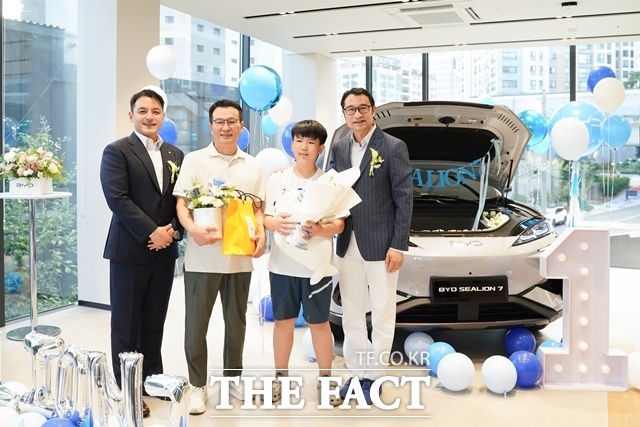 BYD코리아가 10일 부산 동래 전시장에서 씨라이언 7 첫 출고식을 진행했다. 왼쪽부터 DT네트웍스 권혁민 대표이사, 씨라이언 7 첫 번째 고객 가족, BYD 아·태 자동차 영업사업부 류쉐량 총경리가 기념 촬영을 하고 있다. /BYD코리아