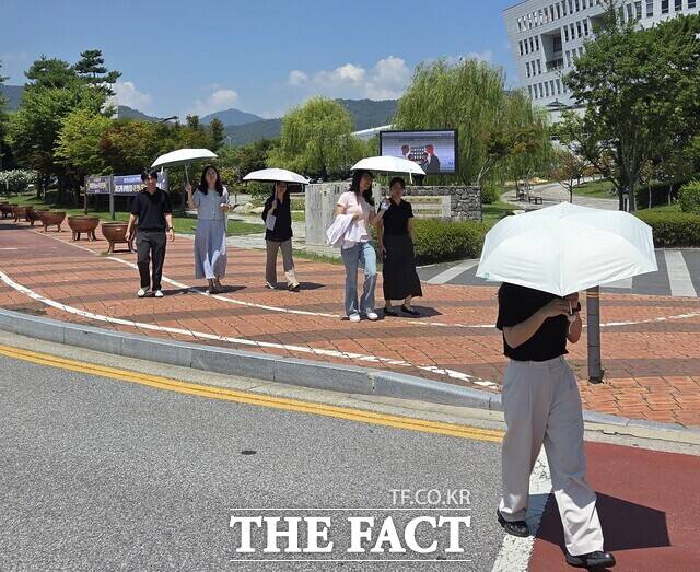 햇살 쉼 양산 펼쳐유 캠페인을 벌이고 있는 충남도교육청 직원들이 양산을 쓰고 외부활동을 하고 있다. /충남교육청