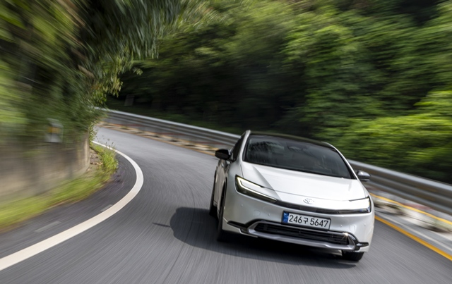 산길 코너를 돌며 주행 중인 토요타 프리우스. 낮고 날렵한 차체와 U자형 주간주행등이 전면부 이미지를 강조한다. /한국토요타자동차