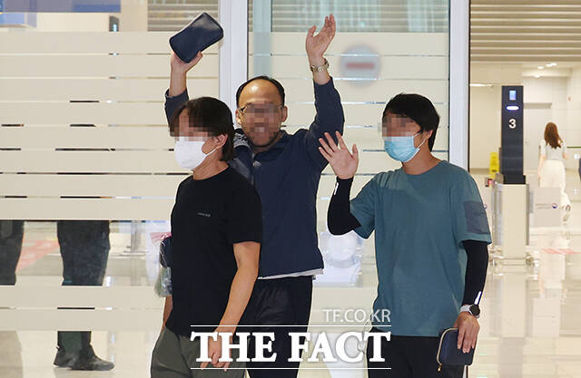 미국 이민 단속으로 구금됐던 현대차-LG엔솔 배터리공장 건설 현장 노동자들이 12일 오후 인천국제공항 제2여격터미널에 도착한 뒤 마중나온 가족 및 관계자들을 향해 손을 흔들고 있다. /인천국제공항=박헌우 기자