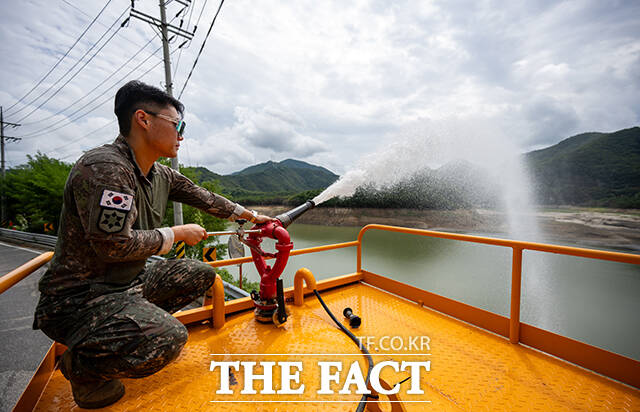 군 장병들이 살수차에 싣고 온 물을 저수지 안으로 쏟아붓고 있다.
