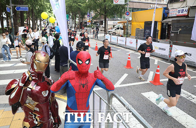 14일 오전 서울광장에서 열린 마블런 서울 2025 행사에서 아이언맨과 스파이더맨으로 분장한 참가자가 러너를 응원하고 있다. /디즈니코리아