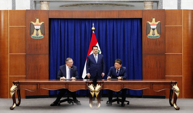 14일(현지 시간) 이라크 총리실에서 열린 계약 서명식에서 토탈에너지스 패트릭 푸얀 CEO(왼쪽), 현대건설 류성안 플랜트사업본부장이 이라크 모하메드 시아 알수다니 총리(가운데)가 지켜보는 가운데 계약을 체결하고 있다. /현대건설