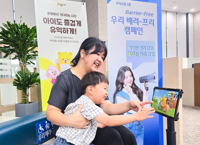 우리은행 지점 내 배려-프리석에서 한 어린이가 부모와 함께 LG유플러스 아이들나라 키즈콘텐츠를 시청하고 있다. /우리은행