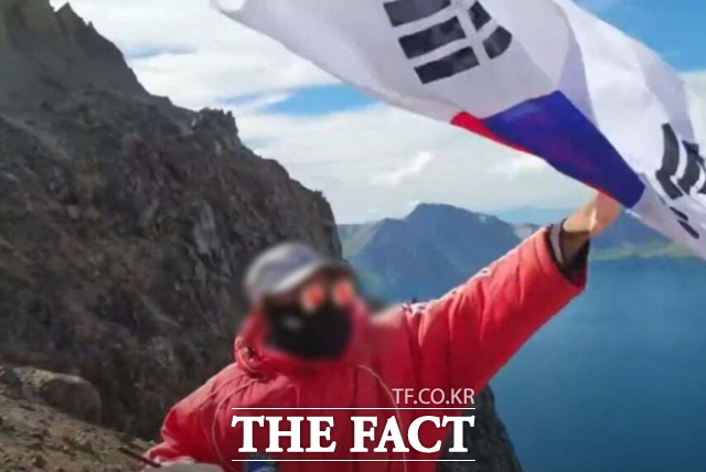 한 유튜버가 백두산 천지에서 태극기를 흔들자 중국 현지 관계자가 이를 제지하는 모습이 포착된 영상. / 유튜브 캡처