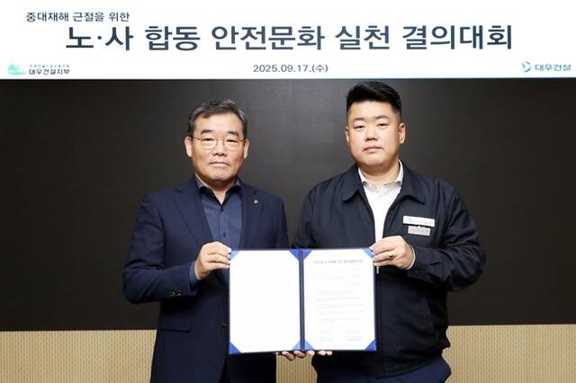 대우건설 김보현 사장(왼쪽)과 심상철 노조위원장(오른쪽)이 대우건설 노사 안전 동행 공동선언문을 채택한 후 기념촬영을 하고 있다. /대우건설