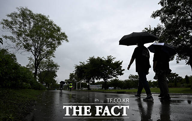 기습 폭우가 쏟아진 17일 오전 서울 여의도 한강공원에서 우산을 쓴 시민들이 발걸음을 재촉하고 있다. /장윤석 기자