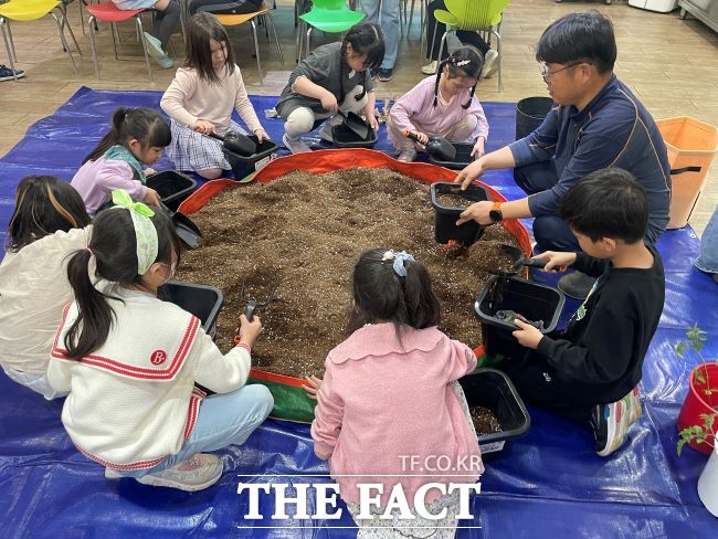 지역아동센터 아동들이 친환경 농부와 상추 모종을 심고 있다. /안양군포의왕과천 공동급식지원센터