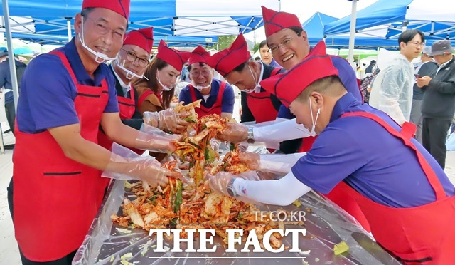 김돈곤 청양군수(오른쪽 2번째)가 19일 제26회 청양 고추·구기자 축제’ 대형 겉절이 담기 코너에서 김기준 청양군의회 의장(가운데), 윤여권 부군수(왼쪽), 주민들과 함께 겉절이를 담고 있다. /김형중 기자