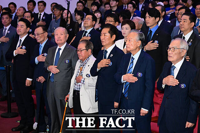 강훈식 대통령 비서실장, 이해찬, 김원기 상임고문, 송춘한 창당70주년기념사업추진 공동위원장, 정청래 대표, 권노갑 김대중재단 이사장, 임채정 상임고문(앞줄 왼쪽부터)이 국기에 경례하고 있다.