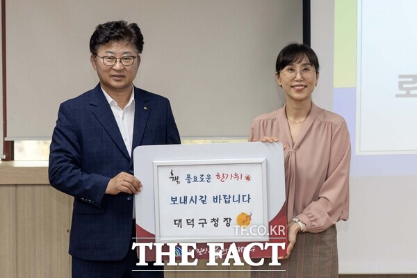 대전 대덕구가 추석 명절을 앞두고 지역 내 사회복지시설을 방문해 위문품을 전달하고 시설 종사자와 입소자들을 격려했다. 최충규 대덕구청장(사진 왼쪽)이 유미영 로뎀 대표에게 위문품을 전달한 후 기념 촬영을 하고 있다./대덕구