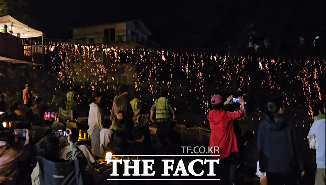 2025 서해 선셋 캠핑 페스티벌에서 서해 바다 위로 붉게 물드는 노을을 배경으로 진행된 서해 선셋 다이닝 장면을 관광객들이 감상하고 있다. /충남문화관광재단