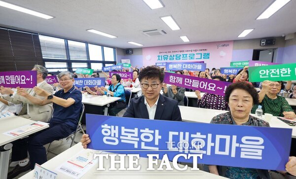 최충규 대덕구청장이 24일 오정동행정복지센터에서 열린 치유상담 프로그램 개강식에 참석해 주민들과 플래카드를 들고 기념 촬영을 하고 있다./대덕구