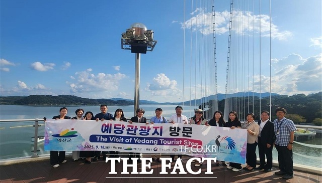 국제 황새복원전략 심포지엄 참석 해외 주요인사들이 예당호 출렁다리 앞에서 기념촬영을 하고 있다. /예산군