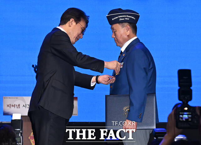 김민석 국무총리(왼쪽)가 24일 서울 송파구 올림픽로 올림픽공원 올림픽홀에서 열린 제73주년 재향군인의 날 기념식에 참석해 양정석 경상북도재향군인회회장에게 국민훈장 목련장을 수여하고 있다.