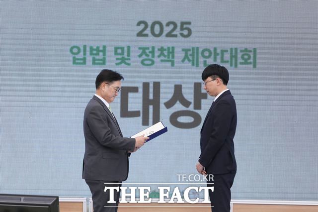 23일 우원식 국회의장(왼쪽)이 2025년 입법 및 정책 제안대회 대상 수상자인 최경환 씨에게 상장을 수여하고 있다. /국회 입법조사처